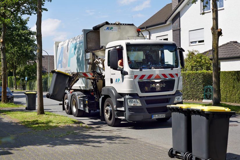 Seitenladerfahrzeug beim Kippen von Behältern