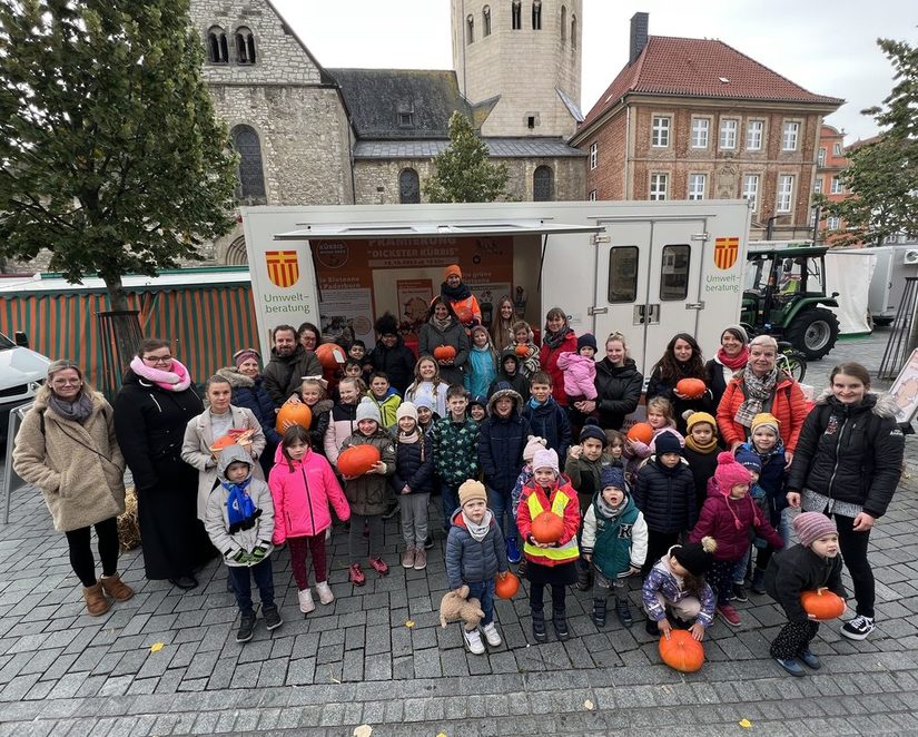 Kinder und Erzieher*innen posieren glücklich für ein Gruppenbild