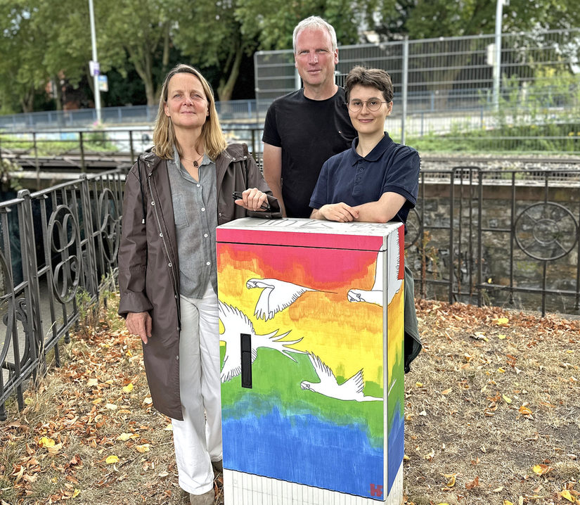 Eine Mitarbeiterin vom Kulturamt der Stadt Paderborn, der stv. Betriebsleiter des ASP und die Workshop-Leiterin vor einem gestalteten Stromkasten.