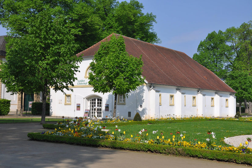 Galerie Außenaufnahme im Sommer mit Wiese und Blumenbeeten im Vordergrund.