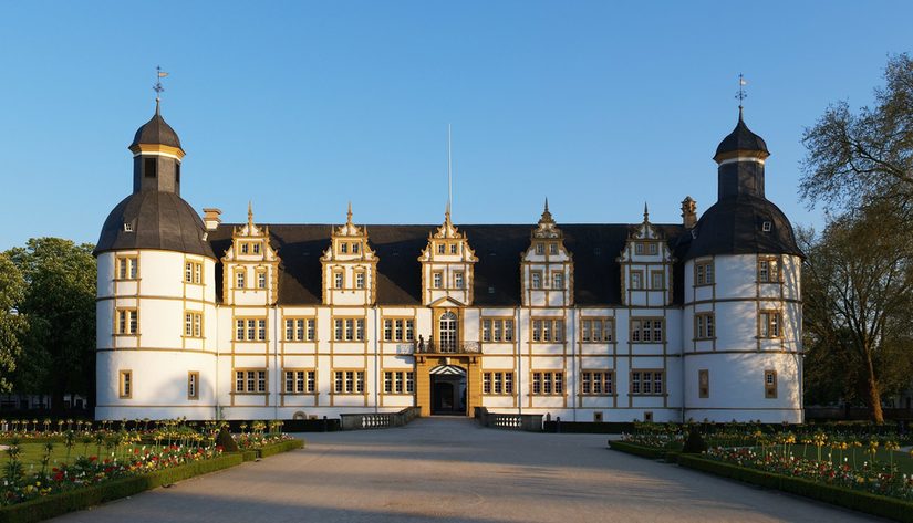 Rückseite des Residenzmuseums bei Tageslicht mit zwei Blumenbeeten an den Seiten.