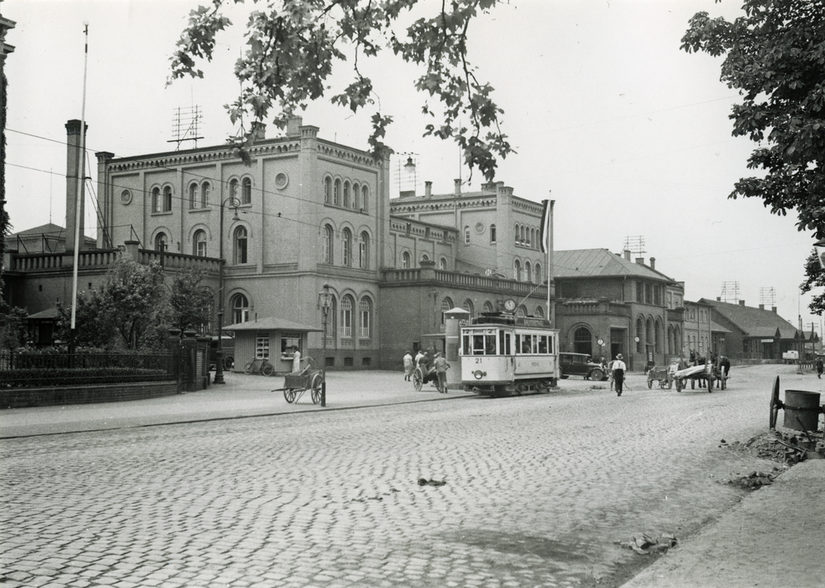 Straße und Straßenbahn vor einem Haus.