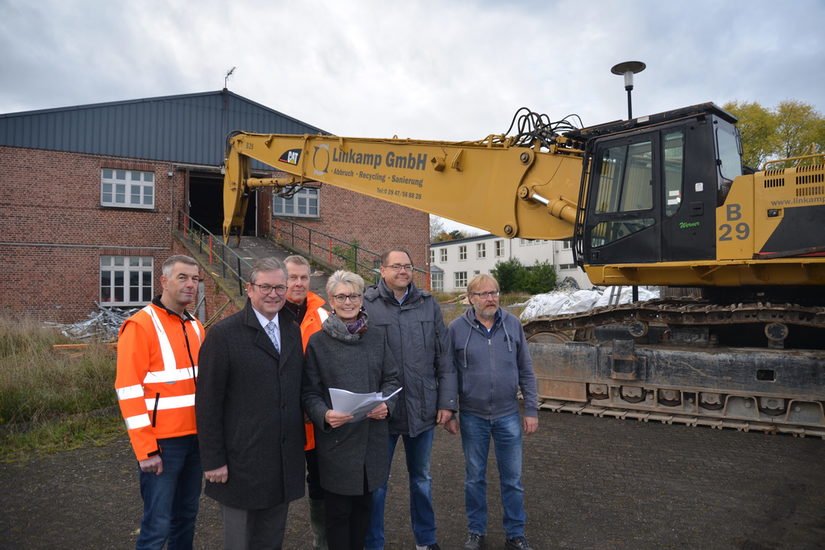 Für die Abrissarbeiten verantwortliche Mitarbeiter neben Abrissbagger